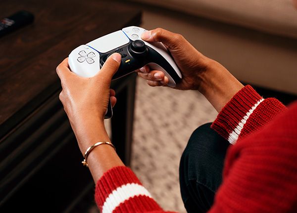 Vista frontal de la PS5 con lector de discos junto a su mando